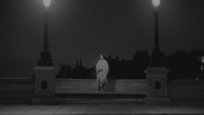 Una persona asseguda entre dos fanals encesos.