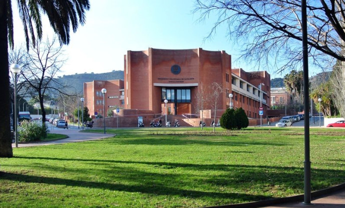 Plaça de gespa i l'edifici Vértex al fons. 